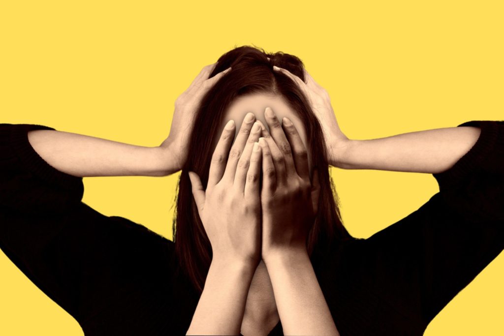 a frustrated woman covering her face with her hands