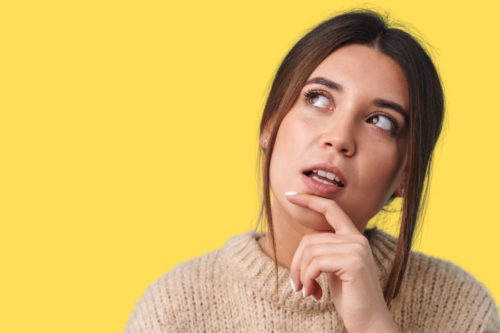 a woman staring up with her finger on her chin