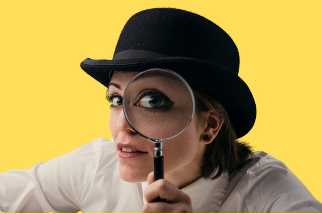 A woman looking into a magnifying glass.