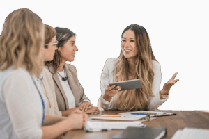 a woman with a tablet discussing something with three other women